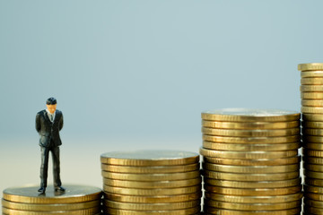 Successful businessman with business planning. Businessmen standing on stacks of golden coins.