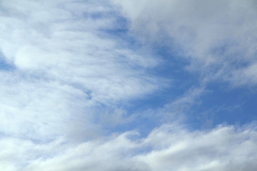 Cloudy blue sky with white and gray clouds. Background for text and design