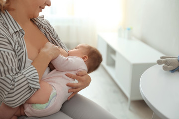 Obraz na płótnie Canvas Young woman breastfeeding her baby at home