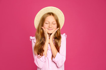 Portrait of preteen girl in hat on pink background