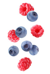 falling blueberries and raspberries isolated on white background with a clipping path.