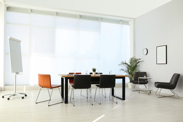 Simple office interior with large table and chairs