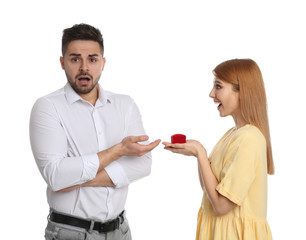 Young woman with engagement ring making marriage proposal to her boyfriend on white background