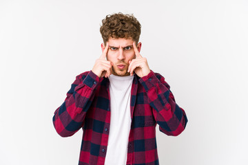 Young blond curly hair caucasian man isolated focused on a task, keeping forefingers pointing head.