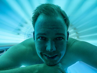 White male tanning in solarium