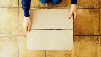 Woman hands opening a parcel contains a gift. Unpacking box with another box. Surprise. Craft present box. People, delivery, shipping service, opening cardboard box or parcel at home.