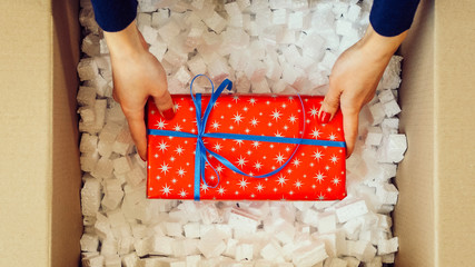 Man hands opening a parcel contains a gift. Unpacking box with another box. Surprise. Red present...