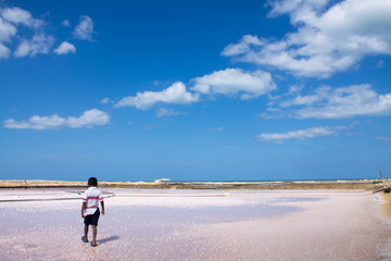 Boy walking in the middle of sea salt.