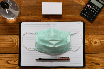 office desk with safety mask and instant hand sanitizer concept of avoiding attack of infectious...