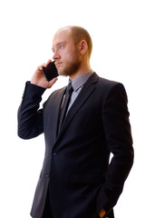 Businessman in a black suit, shirt and tie using a mobile phone in order to keep abreast of all the...