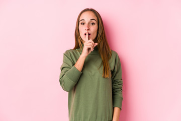 Young caucasian woman posing isolated keeping a secret or asking for silence.