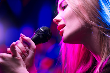 Beautiful Singing Girl, Beauty Glamour fashion Woman with Microphone over Blinking bokeh night...