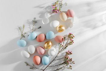 Natural Colored Eggs and flowers with morning sunlights. Stylish minimal Compositions in pastel colors.  Easter concept.