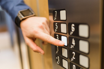 Man pressing modern elevator button with his forefinger.