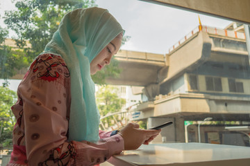 .beautiful Islamic girls use mobile phones while waiting for meal..
