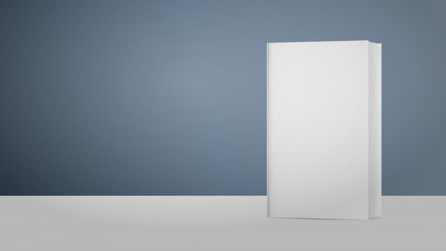White blank book. The book stands on a white wooden table with a gray background. Good for advertising books.