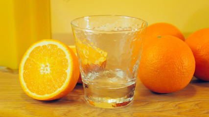 Freshly squeezed orange juice in glass, close-up. Pitcher of orange juice and empty glass on wooden background. Orange juice, healthy, organic drink. Glass of orange juice and orange slices.