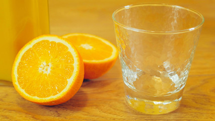 Freshly squeezed orange juice in glass, close-up. Pitcher of orange juice and empty glass on wooden background. Orange juice, healthy, organic drink. Glass of orange juice and orange slices.