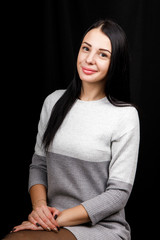 Portrait of serious beautiful female with black hair, has minimal makeup, looks calmly at camera,...