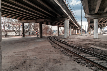 Fototapeta na wymiar Railroad under the freeway. Freeway over railways in an industrial area