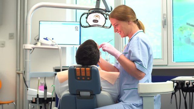 Female ginger dentist is checking her patient