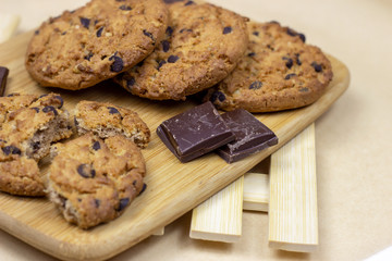 Freshly baked American chocolate chip cookies on rustic brown wooden table background