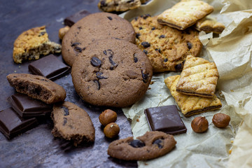 Freshly baked American chocolate chip cookies on rustic black metal table background