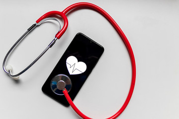 Fototapeta na wymiar Schwarzes Smartphone mit Herzsymbol und Herzschlag und Stethoskop zeigen digitale Patientenakte, digitale Gesundheitsprogramme und Fitnesstracker in der modernen Gesundheitspraxis