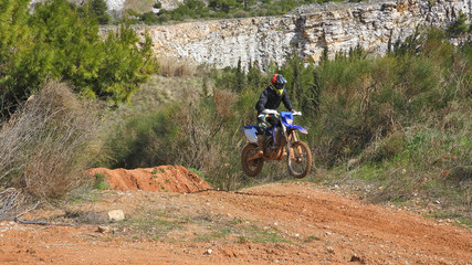Zoom photo of unidentified motocross rider performing extreme stunts in off road dirt track