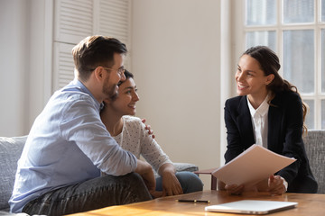 Client and banker seated on sofa discuss mortgage contract terms