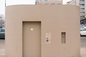 Automatic public toilet with glowing heart on the door. WC in the city with wireless pay. Urban. Public space. Comfortable. Design. Solution