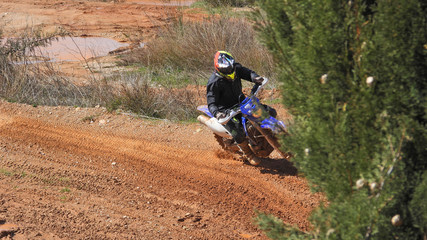 Zoom photo of unidentified motocross rider performing extreme stunts in off road dirt track