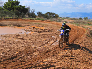 Zoom photo of unidentified motocross rider performing extreme stunts in off road dirt track