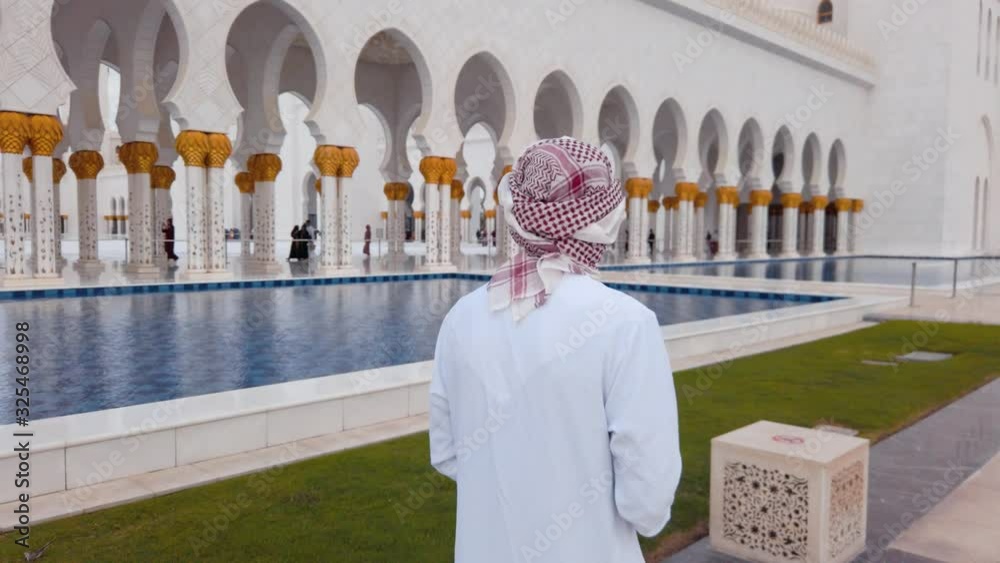 Wall mural Arab man visiting the Grand Mosque in Abu Dhabi slow motion