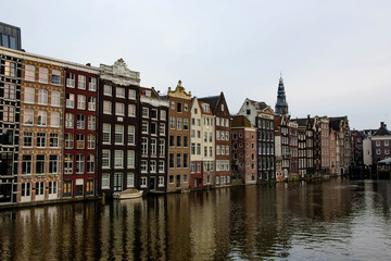 Obraz premium Cityscape of Amsterdam. Dutch city architecture. Modern exterior of buildings. Reflection in water of canal.
