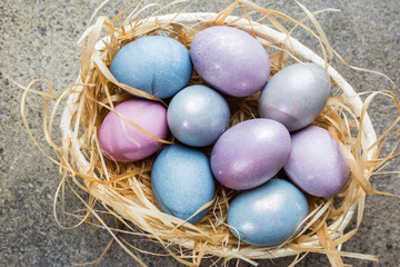 Fototapeta na wymiar Colorful pastel easter eggs on stone background with space for text, top view.