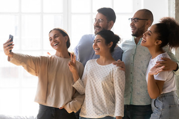 Obraz premium Multi-ethnic friends posing for camera making selfie photo together
