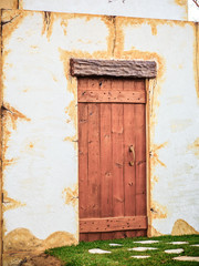 rustic wooden door in white facade.