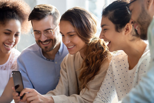 Biracial woman holding smartphone having fun online with multiethnic friends - Powered by Adobe