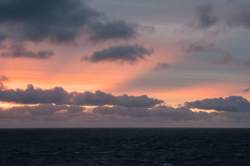 Sonnenuntergang im norwegischen Fjord mit zerklüfteten Wolken