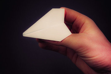 small plane made of paper on a black background