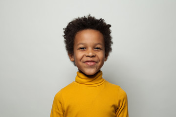 Portrait of happy little black kid boy smiling on white background