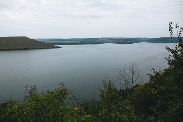 Beautiful view on big lake among hills. River and cliffs landscape. Bakota lake and Dnister river in Ukraine. Travelling and exploring national park. Camping on summer vacation
