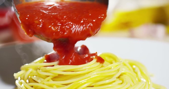 Spaghetti with tomato sauce and basil isolated on white background.