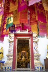 The front door of the temple is decorated with A flag with a religious belief called Tung, Inside the hall is a large Buddha statue.