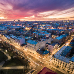 Aerial view of busy city in colorful sunset and street lights. Drone shot of Riga city.  