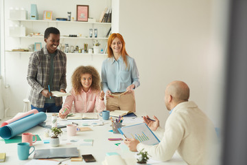 Obraz premium Portrait of diverse business team collaborating on business project during meeting in modern white office and smiling cheerfully