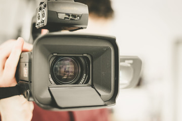 Professional film production: Male filmmaker is recording with a professional movie camera. Close...