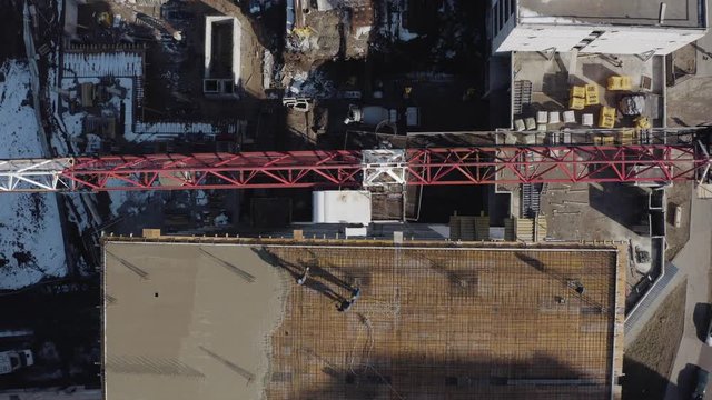 Vertical Shot From Above Of A Crane On A Construction Site In Slow Motion In Kharkov, Ukraine. Tall Crane For Building Aerial View. The Construction Of A New Building For Office Or Apartment Building.