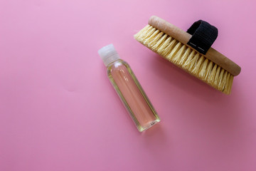 Spa organic brush for dry massage and a bottle of body oil on pink background. Cactus brush and Jar Of Vacuum Cellulite Massage. Anti-cellulite massage. Spa beauty concept